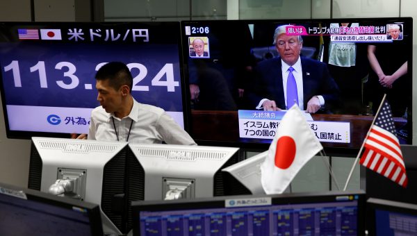 A foreign exchange trader framed by TV news monitors in Tokyo in February 2017. East–West financial linkages are strengthening but Asia remains vulnerable to changes in US and EU financial conditions. (Photo: Reuters/Kim Kyung-hoon).
