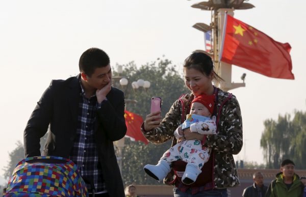 A couple and their baby on the Tiananmen Gate, Beijing, 2 November, 2015 (Photo: Reuters/Kim Kyung-Hoon).