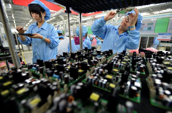 Workers producing electronic panels at a FiberHome Technologies Group factory in Wuhan, China (Photo: Reuters/China Daily).