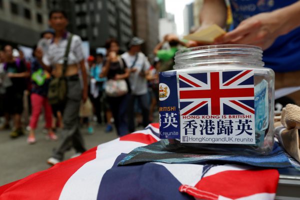 A campaigner on Hong Kong–UK Reunification counts donation during a pro-democracy march on the day marking the 19th anniversary of Hong Kong's handover to Chinese sovereignty from British rule, in Hong Kong, China, 1 July 2016. (Photo: Reuters/Bobby Yip).