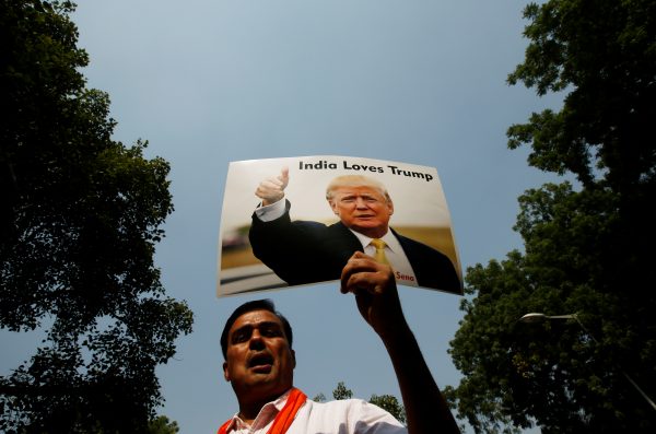 A member of Hindu Sena, a right wing Hindu group, holds a placard of Republican US then presidential nominee Donald Trump during a protest against what they say is a sabotage of his election campaign by US Democratic presidential nominee Hillary Clinton, in New Delhi, India, 18 October 2016. (Photo: Reuters/Adnan Abidi).
