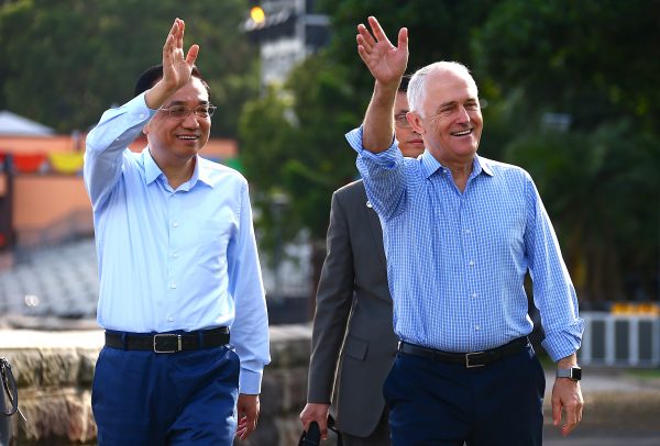 Australia's Prime Minister Malcolm Turnbull waves with Chinese Premier Li Keqiang to members of the public as they walk along the Sydney Harbour foreshore in Australia, 25 March 2017. (Photo: Reuters/David Gray).