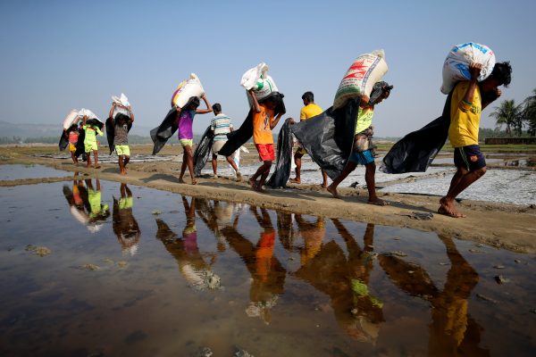 Rohingya refugee workers carry bags of salt as they work in processing yard in Cox's Bazar, Bangladesh, 12 April 2017. (Photo: Reuters/Mohammad Ponir Hossain).
