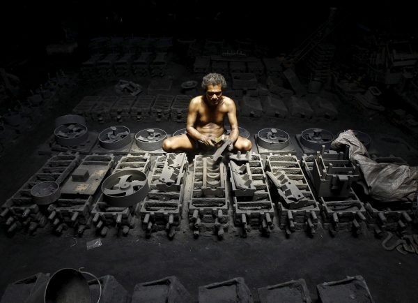 A labourer works inside the manufacturing unit of iron parts at a factory on the outskirts of Kolkata, India, 11 September 2015. (Photo: Reuters/Rupak De Chowdhuri).