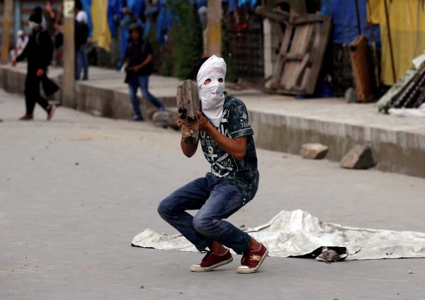 A masked protester prepares to throw a rock towards the Indian police during a protest after Friday prayers in Srinagar, 26 May 2017 (Photo: Reuters/Danish Ismail).