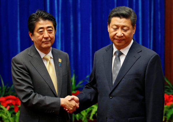 China's President Xi Jinping shakes hands with Japan's Prime Minister Shinzo Abe during a meeting at the Great Hall of the People, Beijing (Photo: Reuters/Kim Kyung-Hoon).
