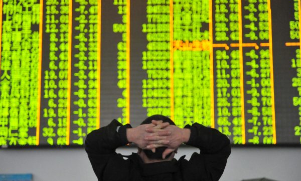 An investor looks at an electronic screen at a brokerage house in Hangzhou, Zhejiang province, 26 January 2016. (Photo: Reuters/China Daily).