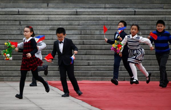 Children run to join the welcoming ceremony for Philippine President Rodrigo Duterte in Beijing in October 2016. (Photo: Reuters/Thomas Peter).