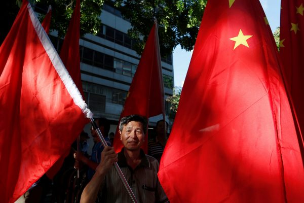 A pro-China supporter holds a Chinese flag he tries to stop pro-democracy activists from protesting during Chinese President Xi Jinping's visit to Hong Kong, China, 1 July 2017 (Photo: Reuters/Tyrone Siu).