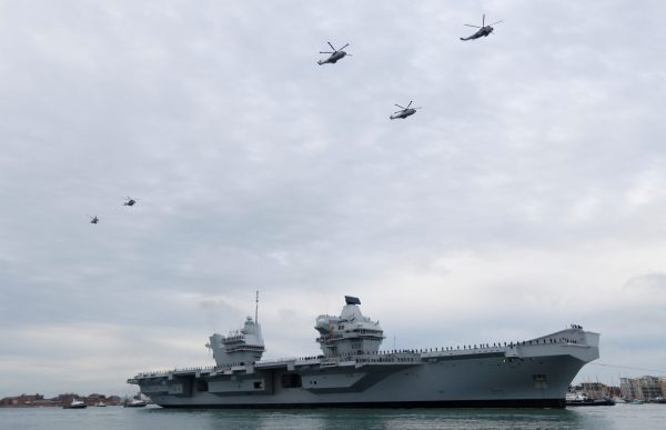 Helicopters fly over the Royal Navy's new aircraft carrier HMS Queen Elizabeth, as it arrives in Portsmouth, Britain, 16 August 2017 (Photo: Reuters/Peter Nicholls).
