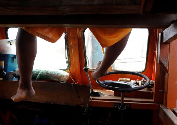 A Philippine fisherman uses his foot to steer his boat at the disputed Scarborough Shoal, 9 April, 2017 (Photo: Reuters/Erik de Castro).