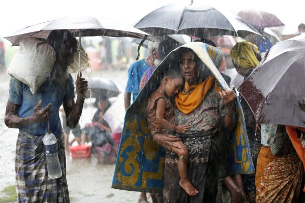 Rohingya refugees stand in an open place during heavy rain, as they are held by Border Guard Bangladesh (BGB) after illegally crossing the border in Teknaf, Bangladesh, 31 August 2017 (Photo: Reuters/Mohammad Ponir Hossain).