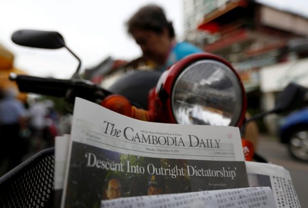 A woman buys the final issue of The Cambodia Daily newspaper at a store along a street in Phnom Penh, Cambodia, 4 September 2017. (Photo: Reuters/Samrang Pring).