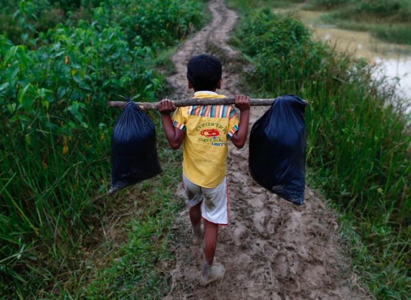 A Rohingya refugee carries his belongings as he walks to a makeshift camp in Cox's Bazar, Bangladesh, 18 September, 2017 (Photo: Reuters/Danish Siddiqui).
