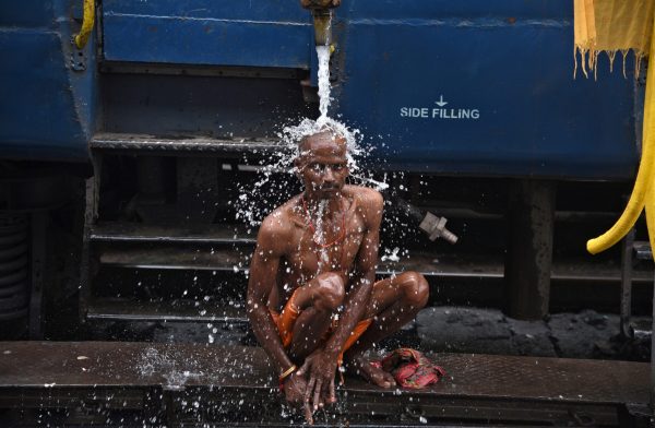 A man bathes using a pipe that supplies water to trains at a railway station in Guwahati, India, 12 August 2017. (Photo: Reuters/Anuwar Hazarika).