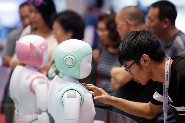 A man programs an iPal Companion Robot by Nanjing Avatar Mind Robot Technology at the 2017 World Robot conference in Beijing, China, 22 August 2017. (Photo: Reuters/Thomas Peter).