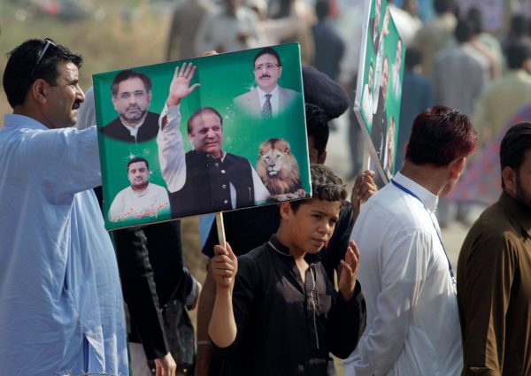 A supporter of Pakistan's former prime minister Nawaz Sharif holds his picture during his appearance at the accountability court in connection with the corruption references filed against him, in Islamabad, Pakistan, 26 September 2017. (Photo: Reuters/Faisal Mahmood).