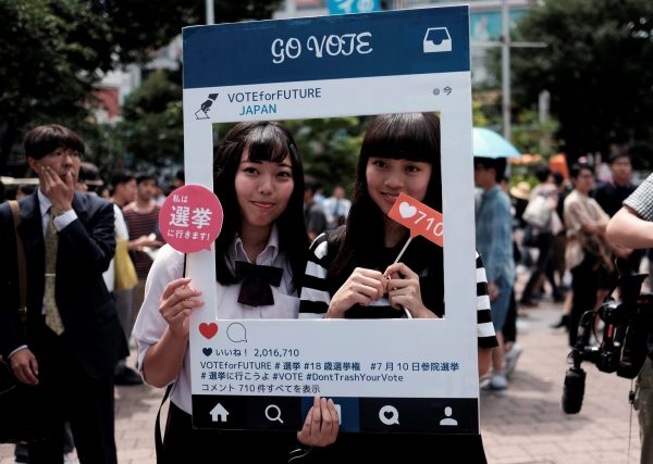 High school students pose for photos with a cardboard Instagram frame calling on youths to vote in the July 10 upper house election, in front of a busy crossing in Shibuya district in Tokyo, Japan 26 June, 2016. Picture taken June 26, 2016. (Photo: Reuters/Toru Hanai).