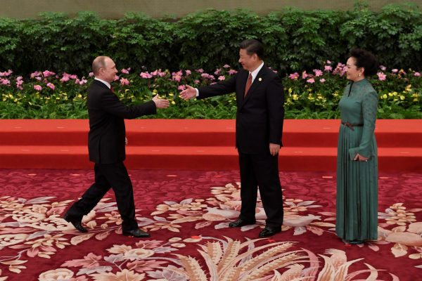 Chinese President Xi Jinping shakes hands with Russian President Vladimir Putin as Xi's wife Peng Liyuan looks on before a group photo during the Belt and Road Forum for International Cooperation at the Great Hall of the People in Beijing, China, 14 May 2017 (Photo: Reuters/Wang Zhao).