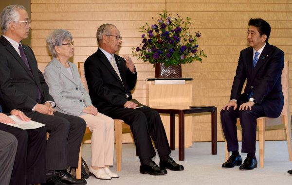 Japanese Prime Minister Shinzo Abe (R) listens to Shigeo Iizuka (2nd R), leader of a group of families of Japanese abducted by North Korea, and its members at his official residence in Tokyo 28 September 2017. (Photo: Reuters/Toshifumi Kitamura).