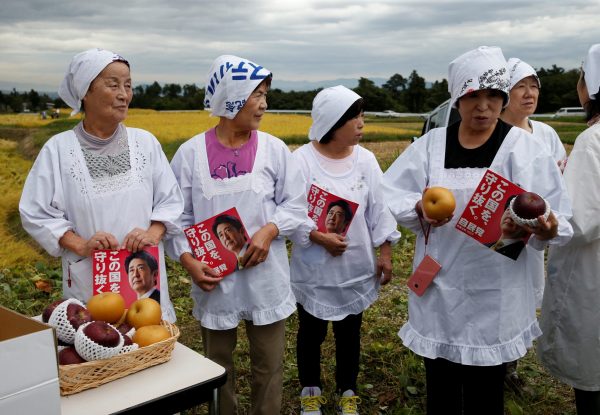 Women hold leaflets of the Liberal Democratic Party's election campaign featuring Japanese Prime Minister Shinzo Abe's photo while they wait for an election campaign rally in Fukushima, Japan, 10 October, 2017 (Photo: Reuters/Toru Hanai).