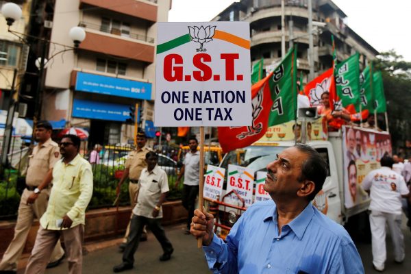A supporter of India's ruling Bharatiya Janata Party holds a placard during a rally to support implementation of the Goods and Services Tax in Mumbai, India, 30 June 2017 (Photo: Reuters/Shailesh Andrade).
