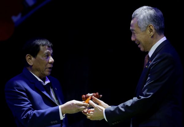 Philippine President Rodrigo Duterte hands over the gavel to Singapore Prime Minister Lee Hsien Loong during a transfer of ASEAN Chairmanship at the closing ceremonies of the 31st ASEAN Summit and Related Summits, 14 November, Manila, Philippines (Photo: Reuters/Aaron Favila).