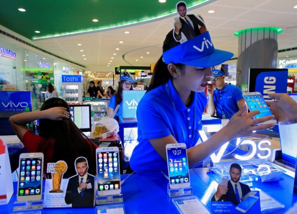 A sales person shows a buyer the features of Vivo mobile phone displayed at a stall inside a Cyberzone of the SM Mall of Asia in Pasay city, metro Manila, Philippines, 7 July 2017. (Photo: Reuters/Romeo Ranoco).