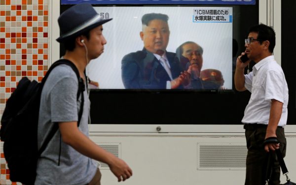 Men walk past a street monitor showing North Korea's leader Kim Jong-un in a news report about North Korea's nuclear test, in Tokyo, Japan, 3 September 2017 (Photo: Reuters/Toru Hanai).