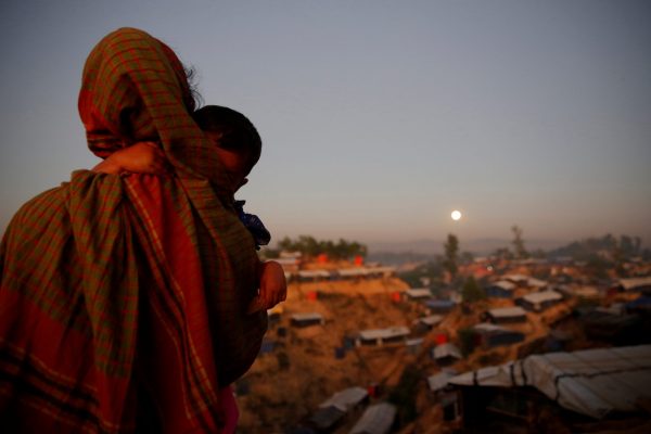 A Rohingya refugee looks at the full moon with a child in tow at Balukhali refugee camp near Cox's Bazar, Bangladesh, 3 December 2017 (Photo: Reuters/Susana Vera).