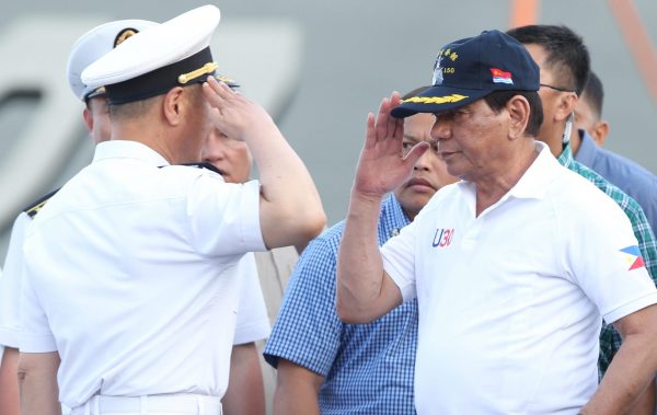 Philippine President Rodrigo Duterte returns the salute of a Chinese naval officer aboard a Chinese vessel visiting Davao City in the southern Phillipines in May 2017 (Photo: Reuters/Lean Daval Jr).