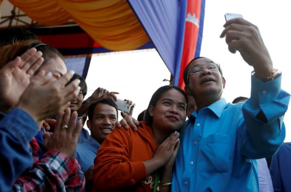 Cambodia's Prime Minister Hun Sen takes a selfie with garment workers before a meeting on the outskirts of Phnom Penh, Cambodia, 8 November 2017. (Photo: Reuters/Samrang Pring).