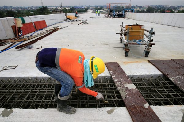 A construction worker stands over the newly dried concrete and secure linking steel bars of the 5.58 kilometre elevated highway in Caloocan City, metro Manila, Philippines on August 2, 2017. Picture taken 2 August 2017. (Photo: Reuters/Romeo Ranoco).