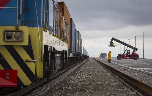 Workers stand next to a train at a container yard at the Khorgos border crossing point, east of the country's biggest city and commercial hub Almaty, Kazakhstan, 19 October 2015 (Photo: Reuters/Shamil Zhumatov).