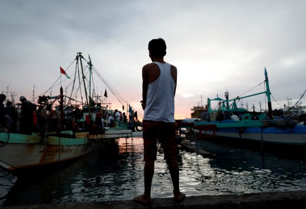 A man, whose wife was arrested during an anti-drug operation and was found dead a day later, stands near fishing boats in Navotas, Metro Manila, Philippines, 5 December 2017 (Photo: Reuters/Dondi Tawatao).