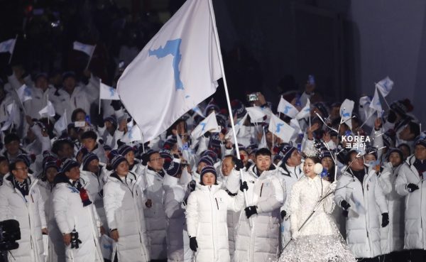 North Korean ice hockey player Hwang Chung Gum and South Korean bobsledder Won Yun-jong carry the unification flag during the opening ceremony (Photo: Reuters/Kim Kyung-Hoon).