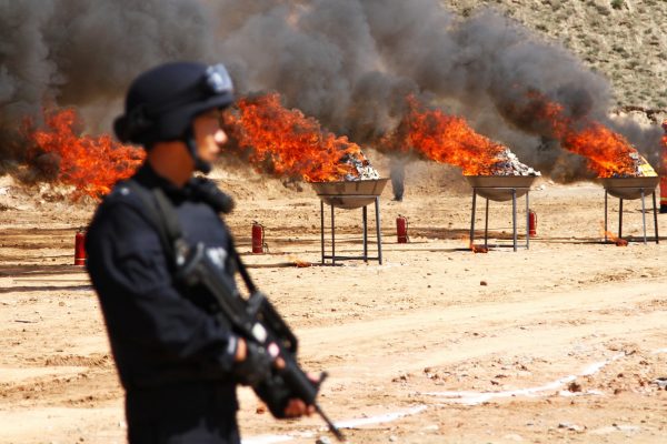 A policeman looks on as confiscated drugs are burned during a campaign ahead of the International Day against Drug Abuse and Illicit Trafficking, in Lanzhou, Gansu province, China, 22 June 2017 (Photo: Reuters/Stringer).