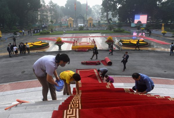Workers lay down red carpet prior to the welcoming ceremony for US President Donald Trump at the Presidential Palace in Hanoi, Vietnam, 12 November 2017 (Photo: Reuters/Hoang Dinh Nam).