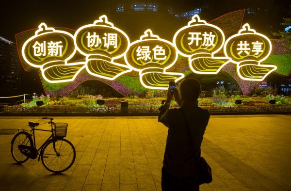 A man takes pictures of a display of Chinese characters representing the Chinese leadership's ‘Five Major Development Concepts’ ahead of the 19th National Congress of the Communist Party of China in Beijing, China, 27 September 2017. The characters read: ‘Innovation, Coordination, Green, Openness and Sharing’ (Photo: Reuters/Thomas Peter).