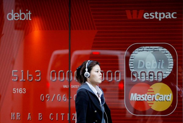 A woman walks past a Westpac bank advertisement in central Sydney 6 May 2009 (Photo: Reuters/Daniel Munoz).