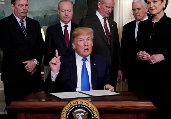 US President Donald Trump, surrounded by business leaders and administration officials, prepares to sign a memorandum on intellectual property tariffs on high-tech goods from China, at the White House in Washington DC on 22 March 2018. (Photo: Reuters/Jonathan Ernst).