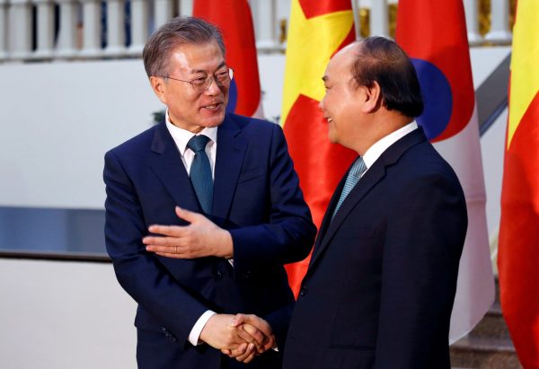 South Korea's President Moon Jae-in (L) chats with Vietnam's Prime Minister Nguyen Xuan Phuc while posing for a photo at the Government Office in Hanoi, Vietnam on 23 March 2018. (Photo: Reuters/Kham).