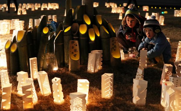 Children look at paper and bamboo lanterns during a memorial event on 11 March 2018 to mourn victims of the 11 March 2011 earthquake and tsunami disaster in Rikuzentakata, Iwate prefecture, Japan (Photo: Reuters/Kyodo).