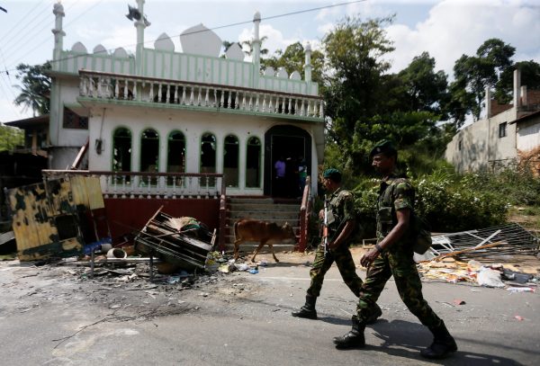Sri Lanka's Special Task Force soldiers walk past a damaged mosque after a clash between two communities in Digana, central district of Kandy, Sri Lanka, 8 March 2018 (Photo: Reuters/Dinuka Liyanawatte).