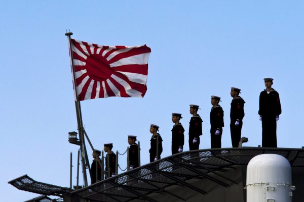 Sailors stand on the deck of the Izumo warship as it departs from the harbour of the Japan United Marine shipyard in Yokohama on 25 March 2015. (Photo: Reuters/Thomas Peter.)
