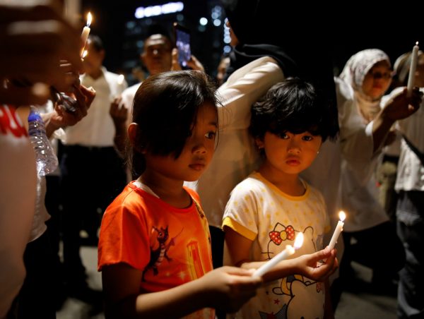 Children attend a candlelight ceremony in support of victims and victims' families of the recent attacks at police stations and churches in Jakarta and Surabaya, in a park in Jakarta, Indonesia, 15 May 2018 (Photo: Reuters/Darren Whiteside).