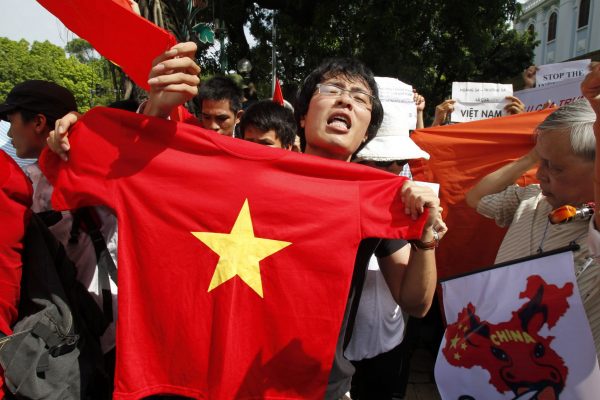 A protester holds a tee-shirt bearing the yellow star of the Vietnamese national flag during an anti-China demonstration near the Chinese embassy in Hanoi 3 July 2011. Protesters took to the street in Hanoi for a fifth consecutive Sunday to rally against China's activities in the South China Sea. Relations between China and Vietnam have been strained over the past month because of a flare-up in a long-standing dispute over sovereignty in the South China Sea. The two sides each conducted naval exercises in a show of force but analysts say neither has an interest in pushing the dispute to the point where military conflict is a serious risk (Photo: Reuters/Kham).