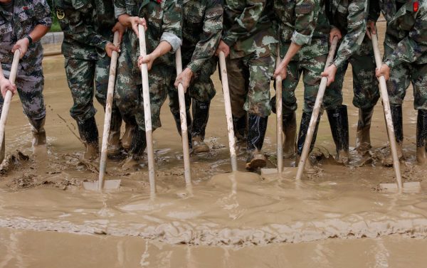 Paramilitary policemen sweep a flooded street in Guilin, Guangxi province, China, 3 July 2017 (Photo: Reuters/Stringer).