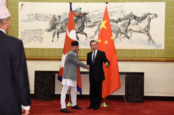 Nepalese Foreign Minister Pradeep Kumar Gyawali, left, shakes hands with Chinese Foreign Minister Wang Yi as they pose for media before their meeting on 18 April 2018 at the Diaoyutai State Guesthouse in Beijing, China. (Photo: REUTERS/Parker Song.)