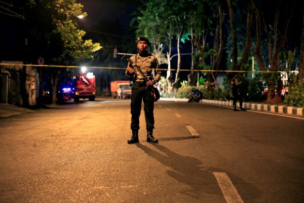 A policeman stands guard outside a church, one of the three hit by suicide bombers in Surabaya, Indonesia, 13 May 2018 (Photo: Reuters/Beawiharta).